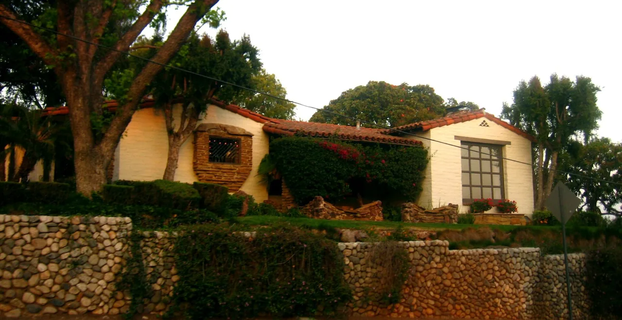 Yellow Spanish Colonial Revival stucco house with red tile roof